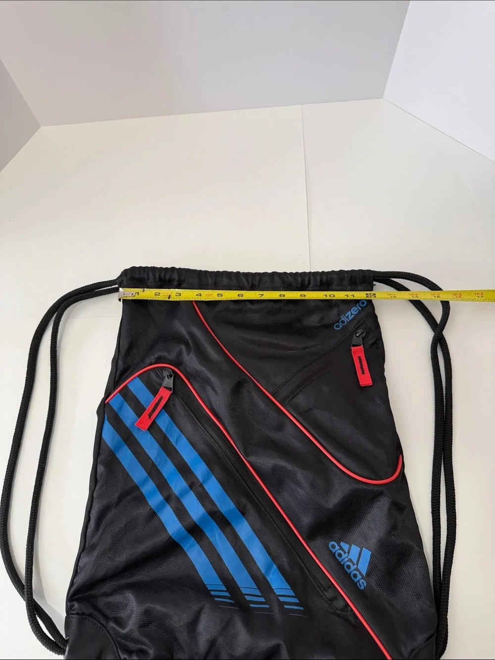 adidas Black Drawstring Backpack with Blue Stripes and Red Accents